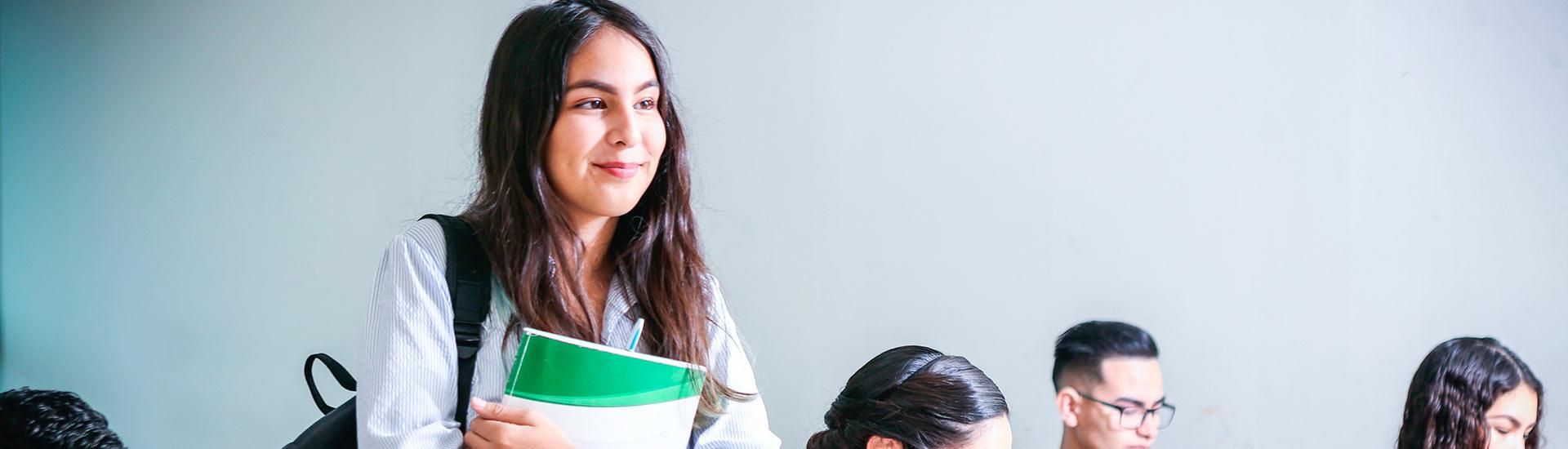 young female college student with dark hair standing up in class