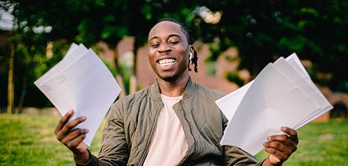 Young African American man holding papers and smiling